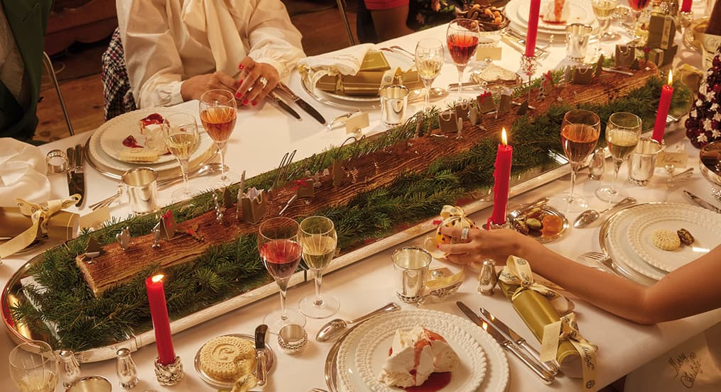 christmas table with candelabras on a festive red tablecloth and christmas tree